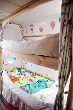 bunk beds in a small room with hot air balloons on the wall