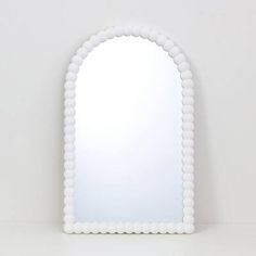 a white mirror sitting on top of a table