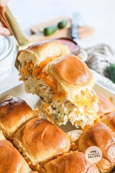 chicken and cheese sliders cut in half on a white plate with a gold fork