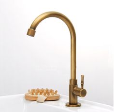 a brass faucet with toothpicks in front of it on a white countertop