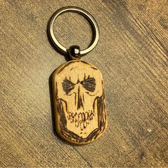 a wooden keychain with a carved skull on it