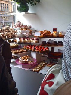 people standing in front of a counter filled with pastries