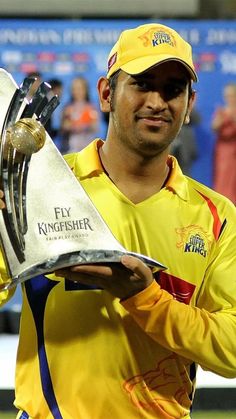 a man holding a trophy on top of a field