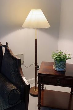 a living room with a couch, table and lamp on the side by it's wall