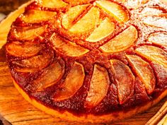 a pineapple upside down cake sitting on top of a wooden cutting board next to cinnamon sticks