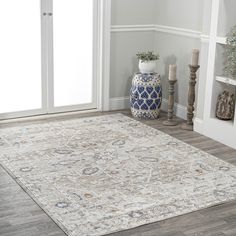 a large area rug in the middle of a room with two vases on either side