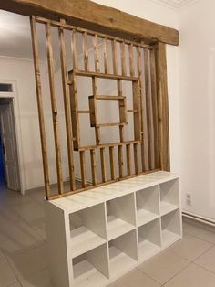 an unfinished room with white shelves and wooden frames on the wall, in front of a blue door