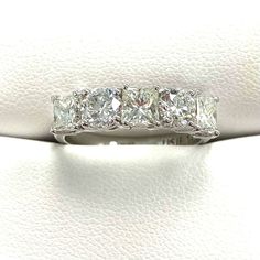 a wedding ring with five princess cut diamonds