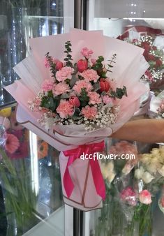 a bunch of flowers that are sitting on a stand in front of a glass case