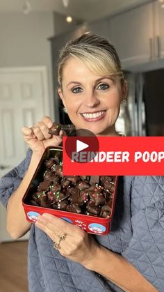 a woman holding up a box of chocolates with the words kinder popcorn on it