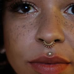 a close up of a woman's nose with a piercing on her nose ring