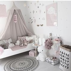 a bedroom with pink and white decor, including a teepee tent over the bed