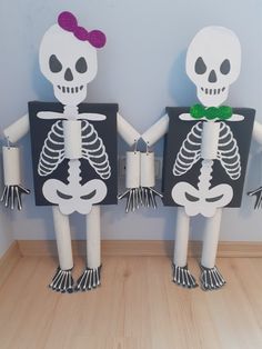 two paper skeletons are holding hands and standing next to each other