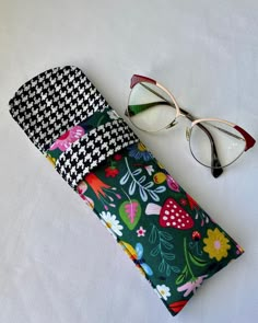 a pair of glasses sitting on top of a white table next to a wallet and eyeglass case