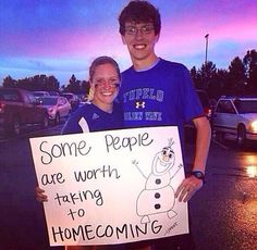 two people holding a sign that says some people are worth, taking to home coming