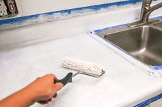 a person using a brush to clean a kitchen counter