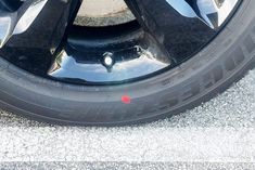 the tire of a black car with red lettering on it's sidewalls