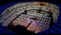 an aerial view of the stadium's stands at night, with lights on them