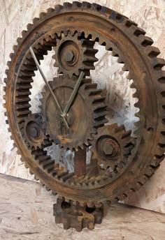 an old clock made out of gears on a wall in a room with marble walls