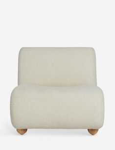 an upholstered white chair with wooden legs