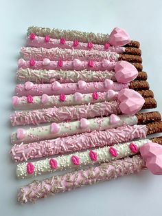 pink and white decorated cookies arranged in rows