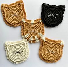 four woven coasters with cat faces on them