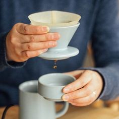 a person pouring coffee into a cup