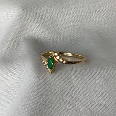 a green ring sitting on top of a white cloth