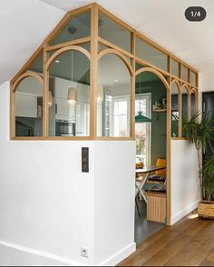 the interior of a house with wood trimming and glass windows on the wall, along with a potted plant