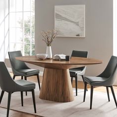 a dining room table with chairs around it and a vase on the table next to it