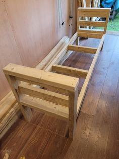 a wooden bed frame sitting on top of a hard wood floor next to a wall