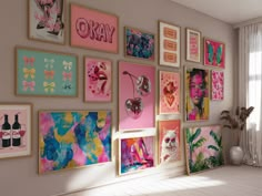 there are many framed pictures on the wall in this room with pink and blue accents