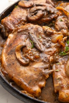 some meat and mushrooms are in a skillet