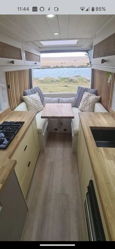 the inside of a camper with wood flooring and counter tops in front of it