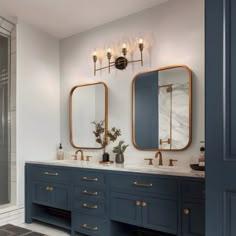 a bathroom with two sinks, mirrors and a walk - in shower next to it