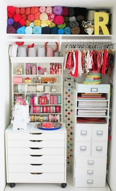 an organized closet with white drawers and lots of crafting supplies on top of it