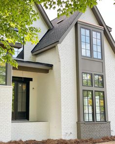 a white brick house with black trim and windows