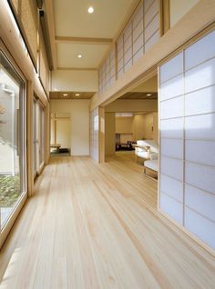 an empty room with wood flooring and white wall covering the walls, along with sliding glass doors