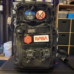 nasa backpack with patches on it sitting in a room