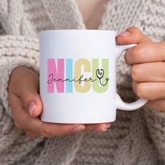 a woman holding a coffee mug with the word nannu on it in multicolored letters