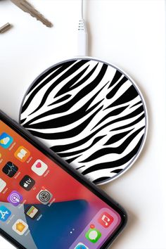 an iphone with a zebra print on it next to a charger