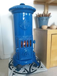 a blue stove sitting on top of a tiled floor