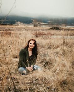 a woman is sitting in the tall grass