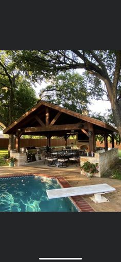 a pool with a covered patio next to it and an outdoor dining area in the background