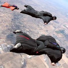 two people are in the air with parachutes