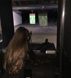 a woman with long hair shooting at a target