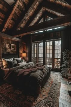 a large bed sitting inside of a bedroom on top of a wooden floor next to a window