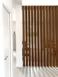 a bathroom with wooden slats on the wall and tiled flooring in front of it