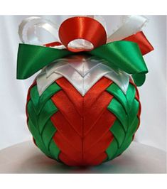 an ornament shaped like a christmas ball with a green and red bow on top