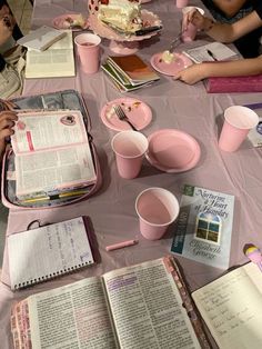 several people sitting at a table with books and drinks